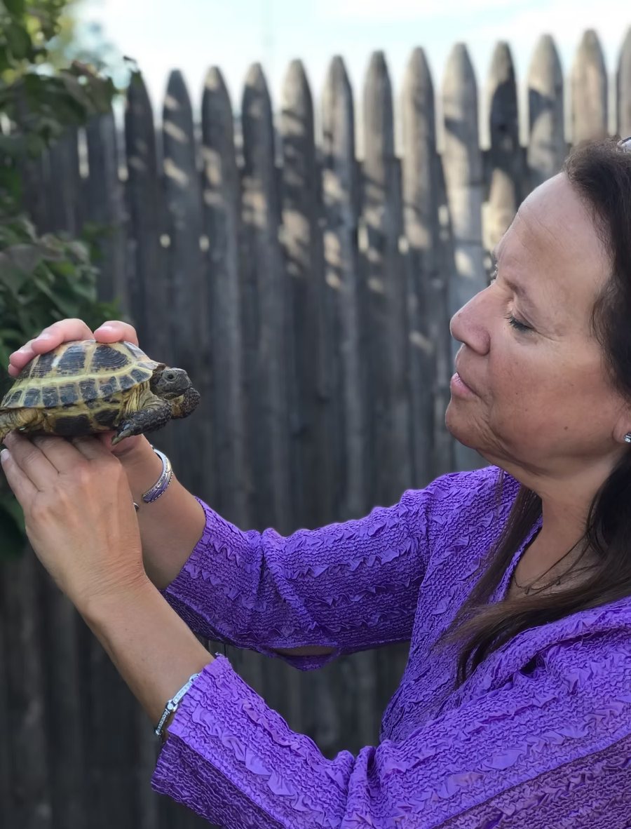 Donna Sue Rosenthal holding a tortoise at eye level
